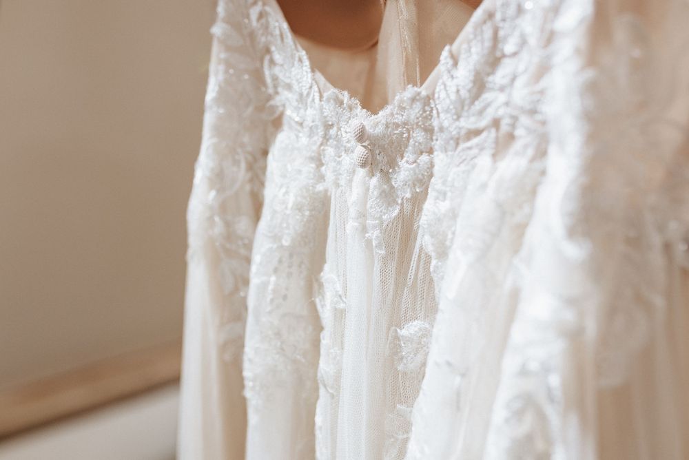 Delicate white lace and embroidery details on a vintage-style wedding dress bodice.