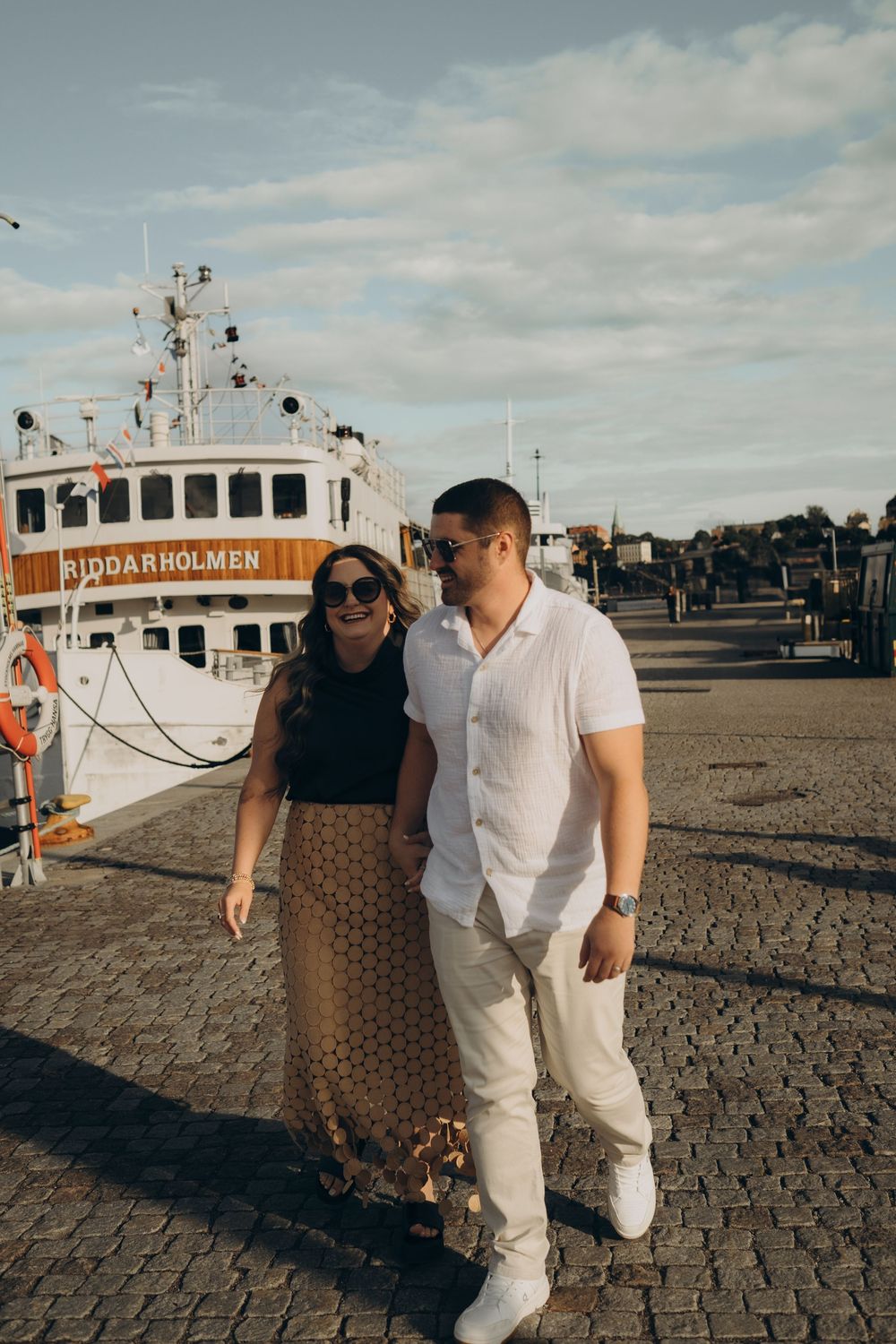 couple taking a walk in a harbour while being captured by the best couple photographer for tourists in Stockholm
