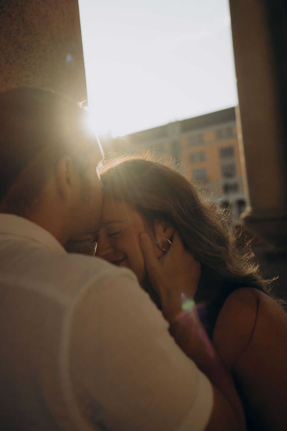 man kissing woman's forehead while being captured by best couple photographer in Stockholm for romantic relaxed photo session