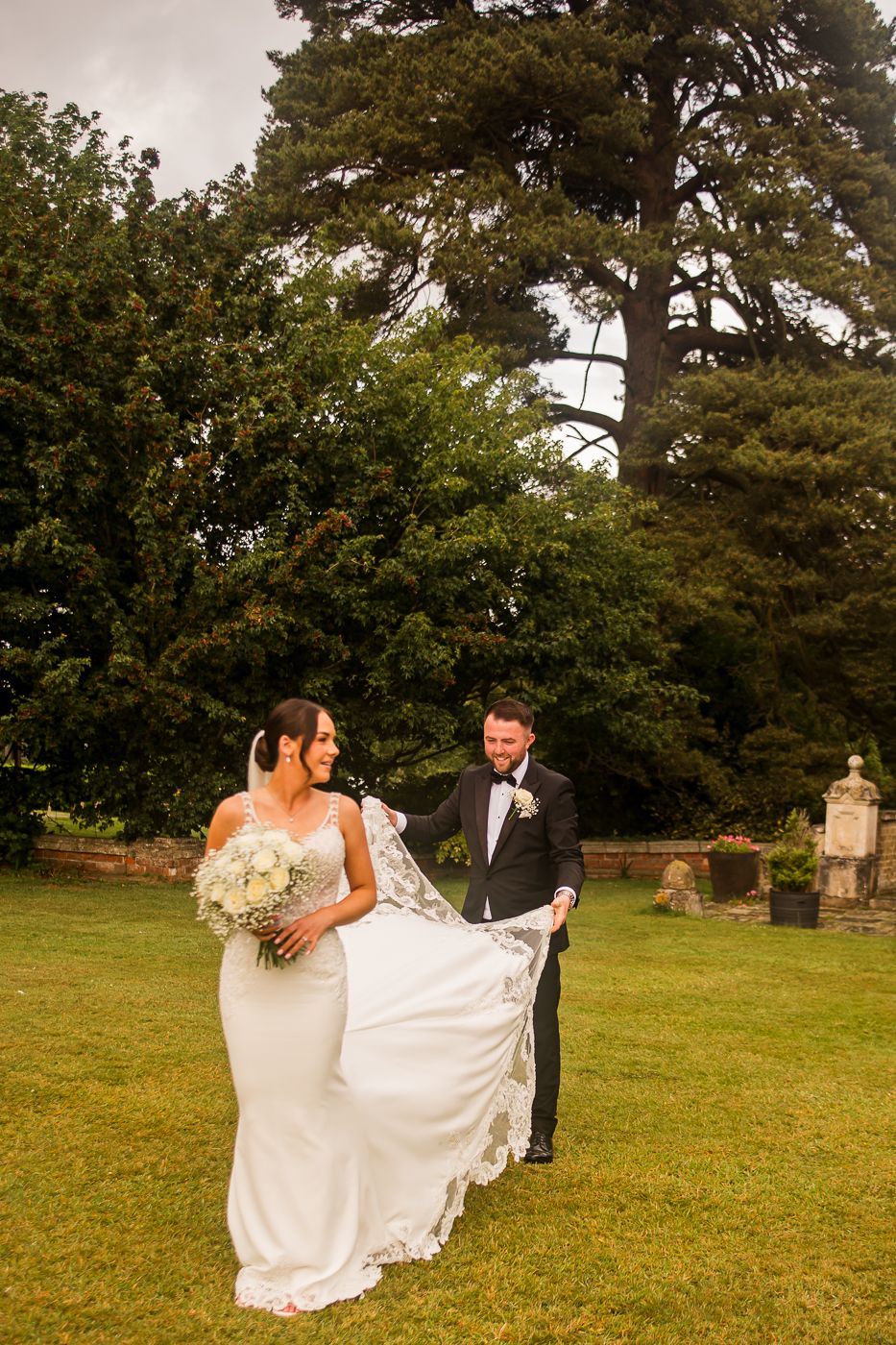 Bride and groom sharing romantic moments in an outdoor garden setting.