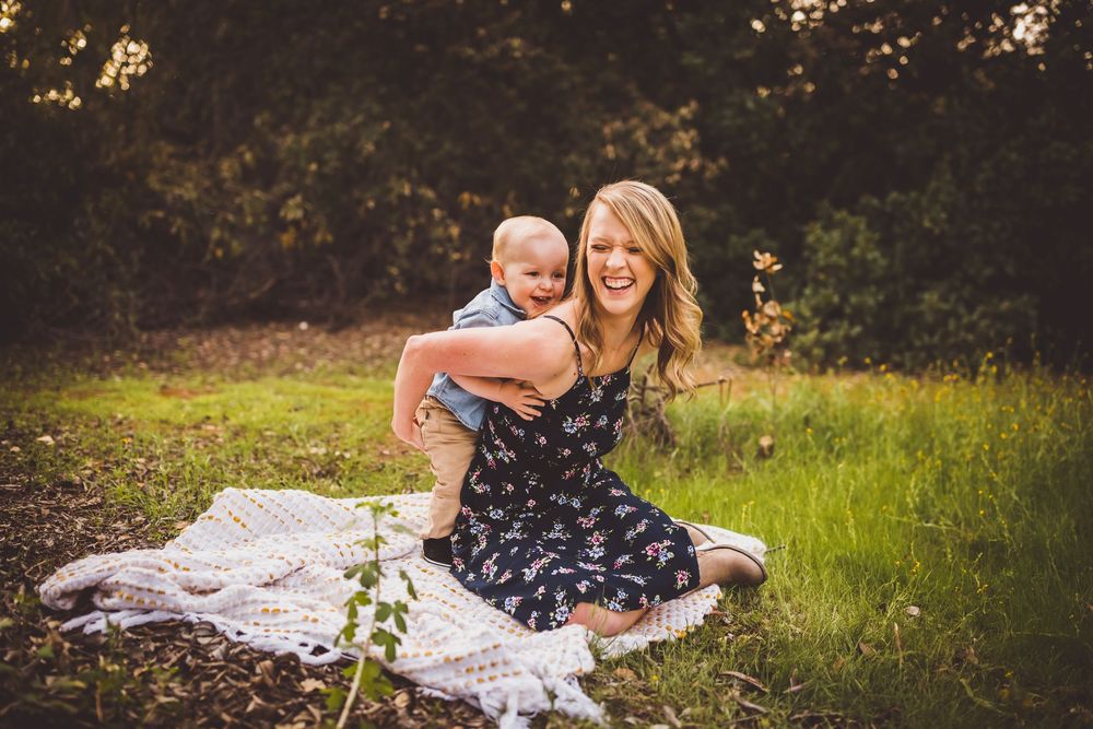 A heartwarming outdoor portrait session in a sunlit meadow with a white blanket.