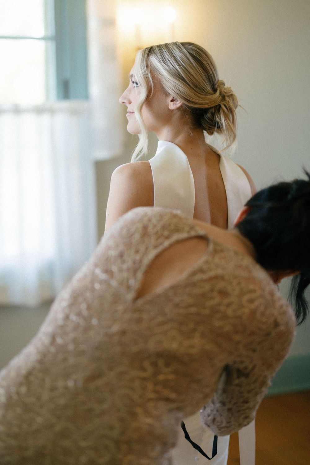 Close-up of lace detail on formal dress in soft window light.