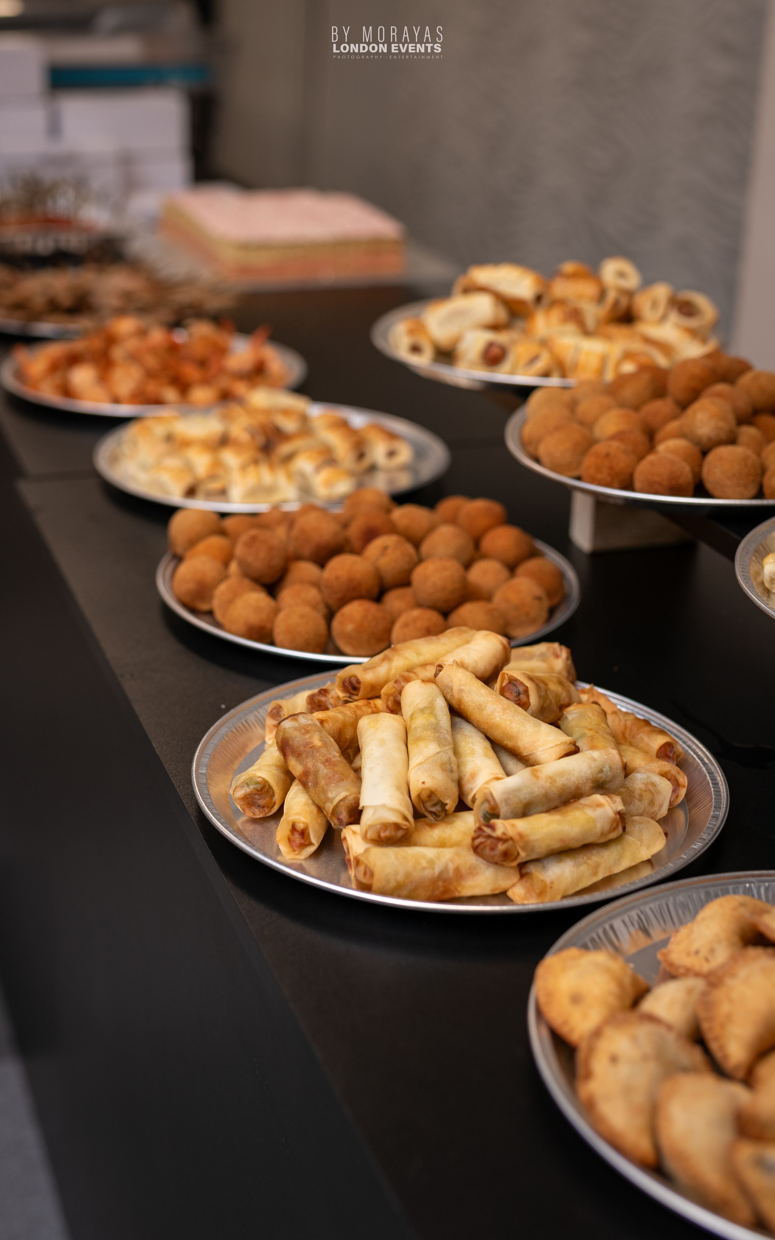 Platters of golden fried appetizers and hors d'oeuvres arranged on a buffet table.