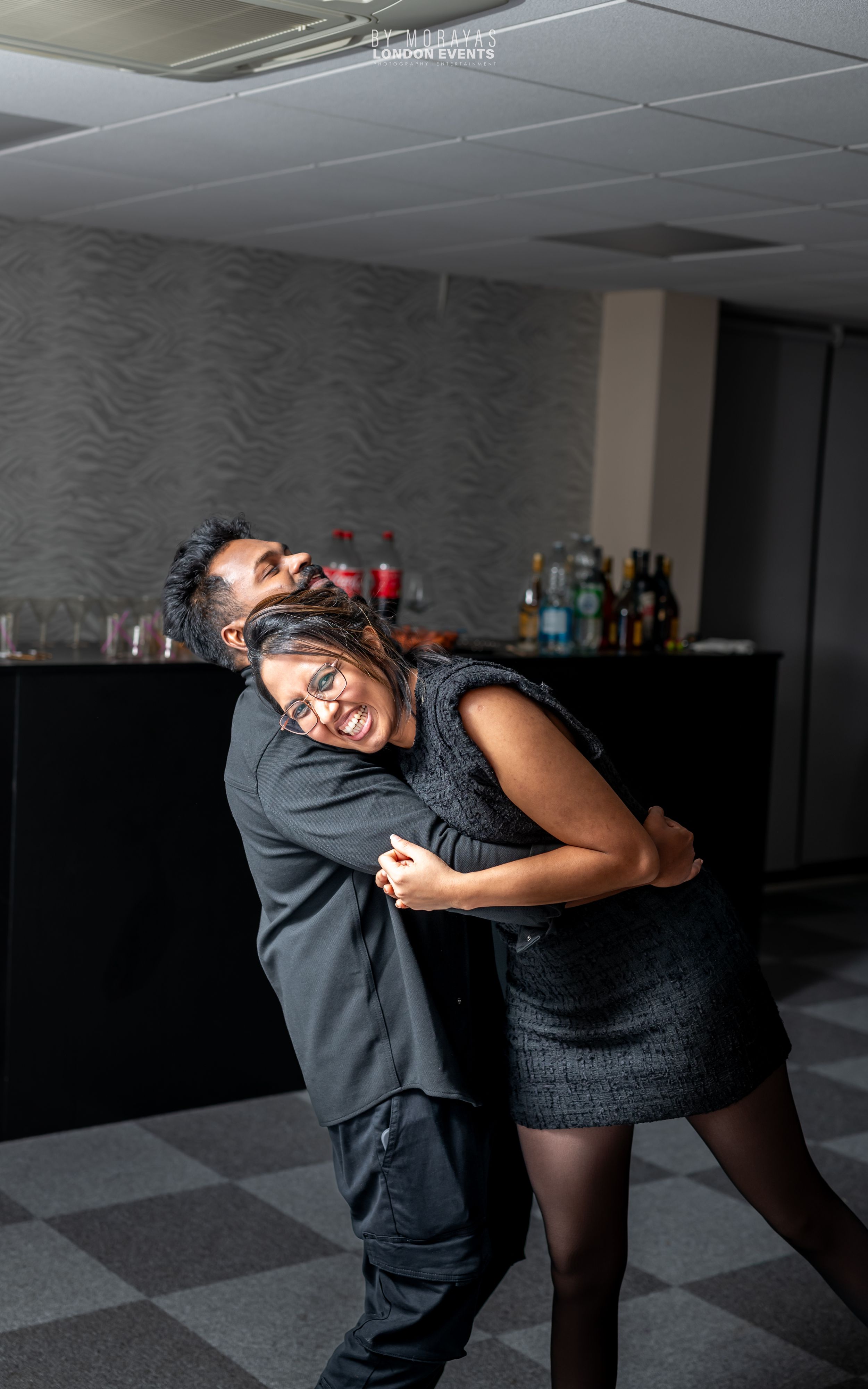Dancing couple in formal attire sharing an intimate moment at a party.