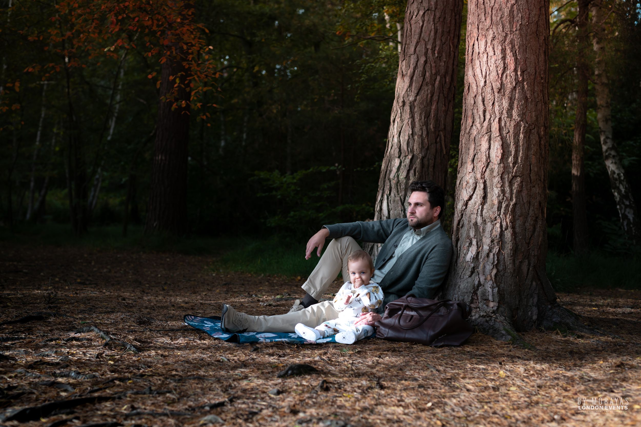 Outdoor family photography session among tall pine trees in natural setting.