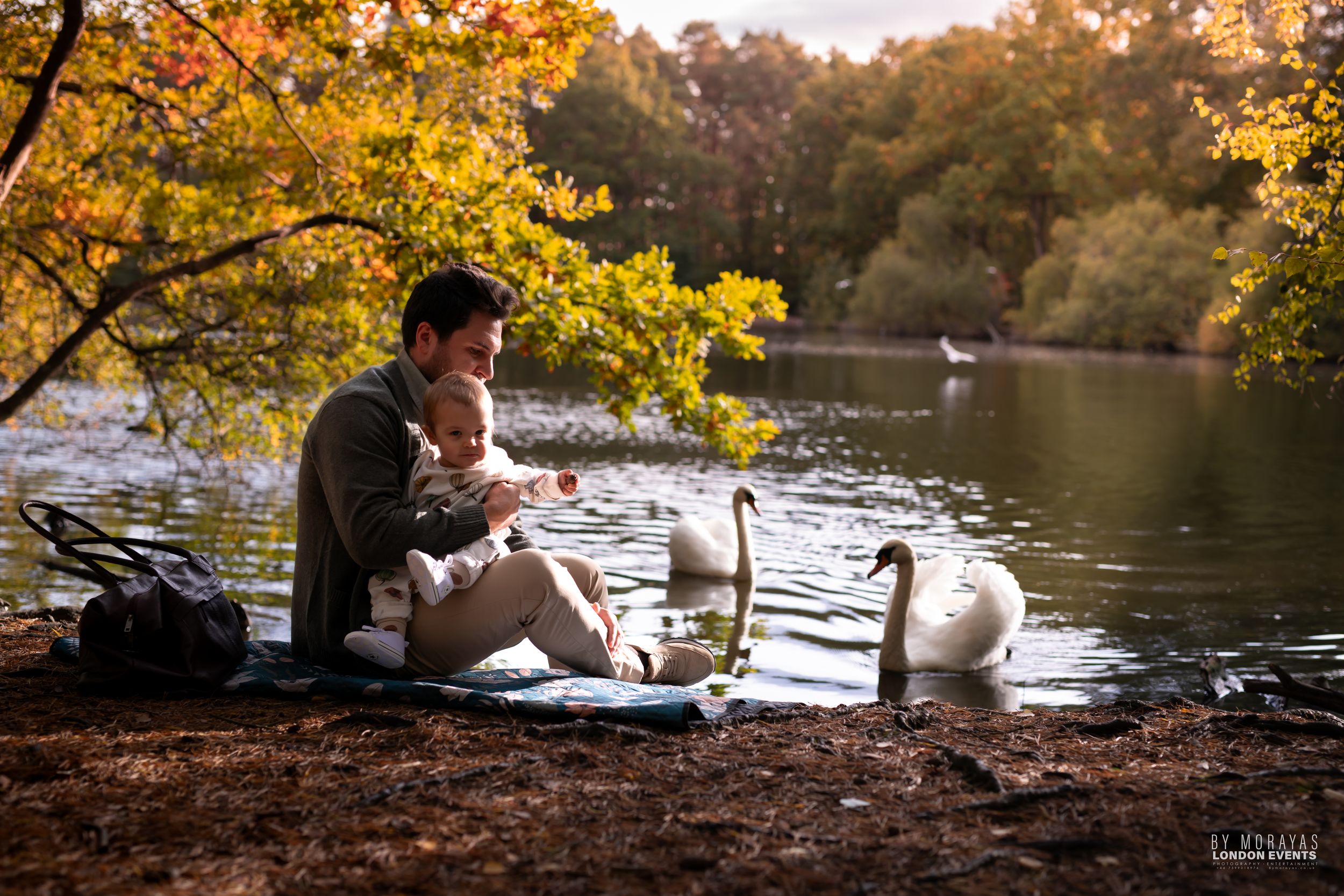 Scenic autumn lakeside photography session with golden foliage and water reflections.