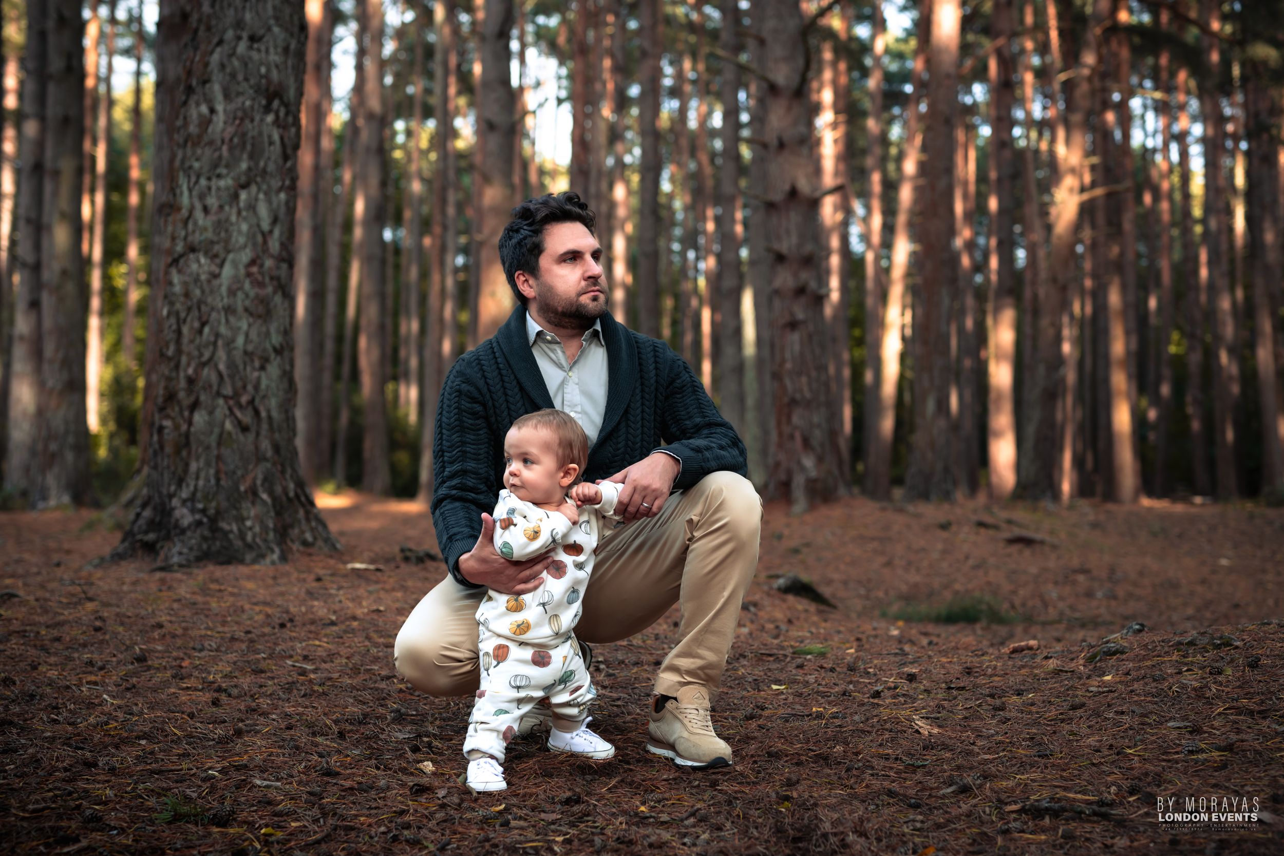 Natural woodland photography session among tall pine trees in golden light.