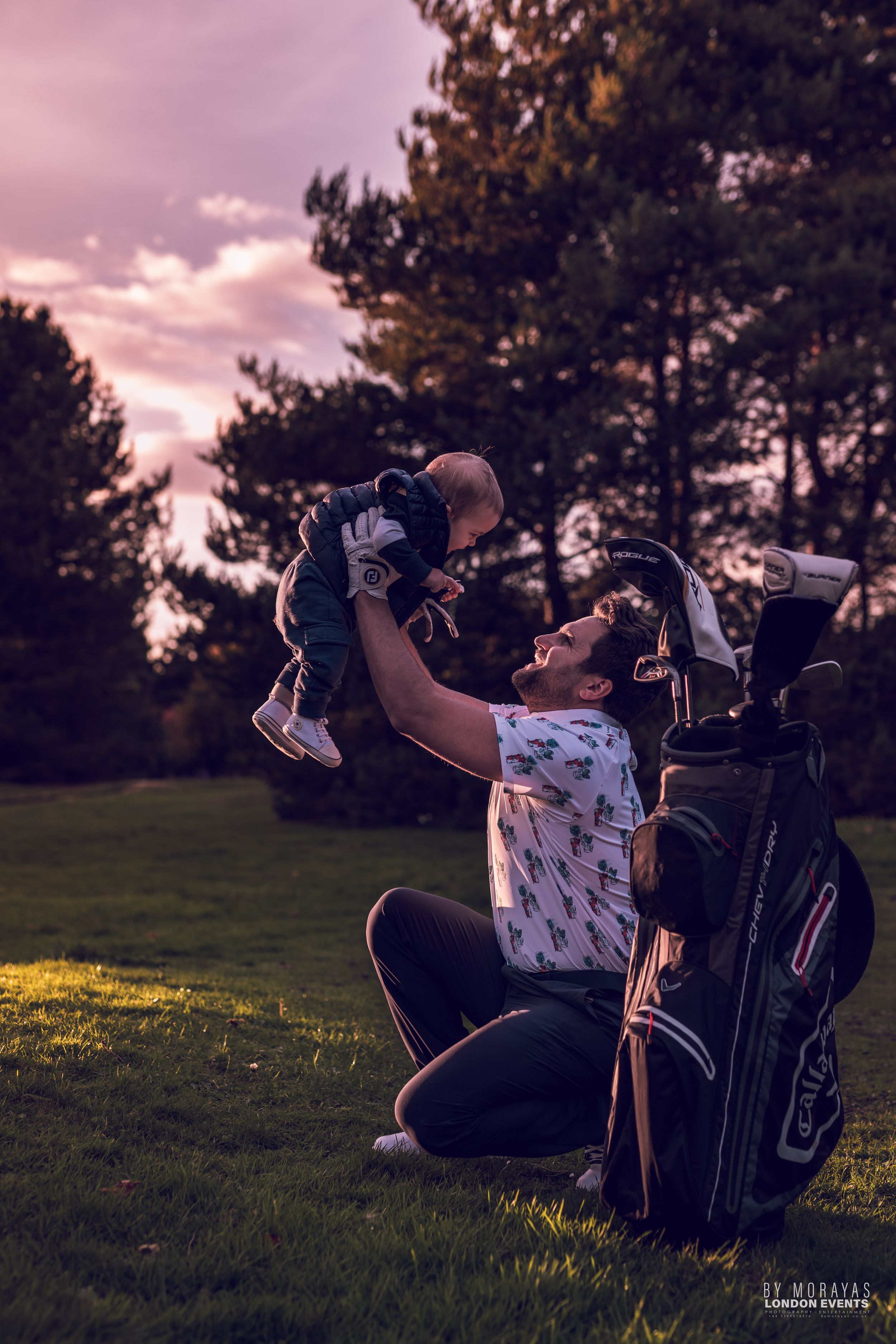 A joyful moment on a golf course at sunset with a golf bag visible in the scene.