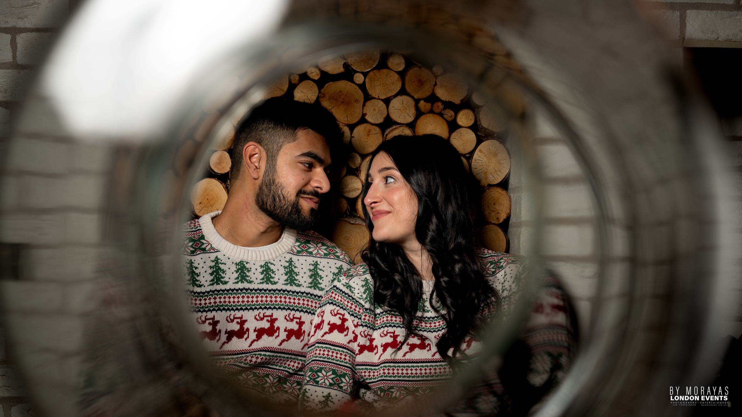 Framed photos through glass showing intimate moments against a brick wall background.
