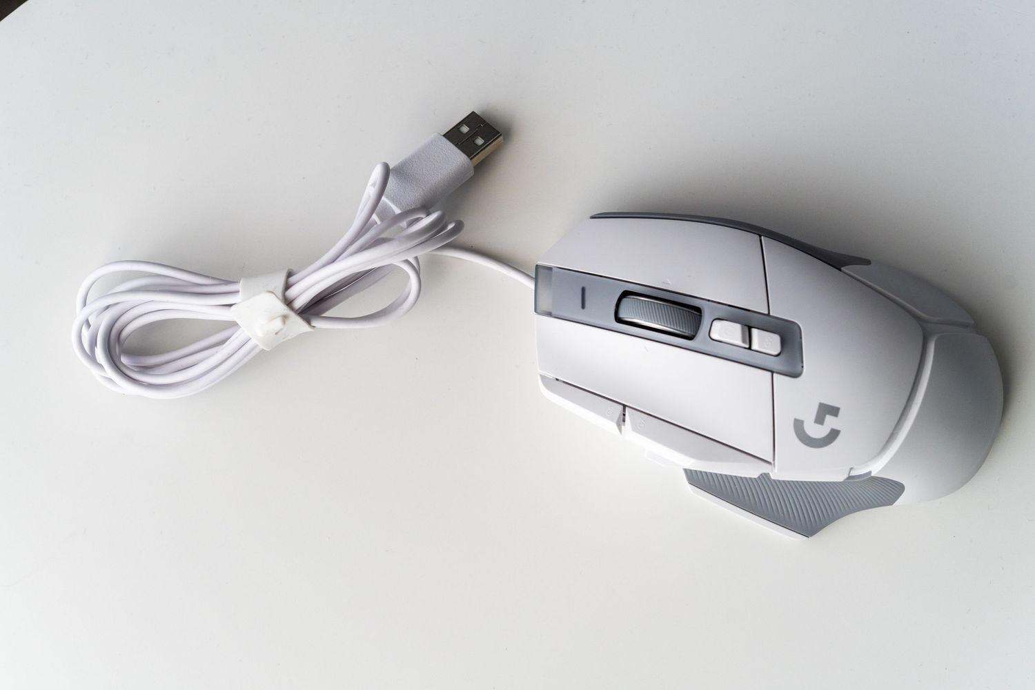 A series of white computer mice and gaming peripherals arranged in a row on a light gray background.
