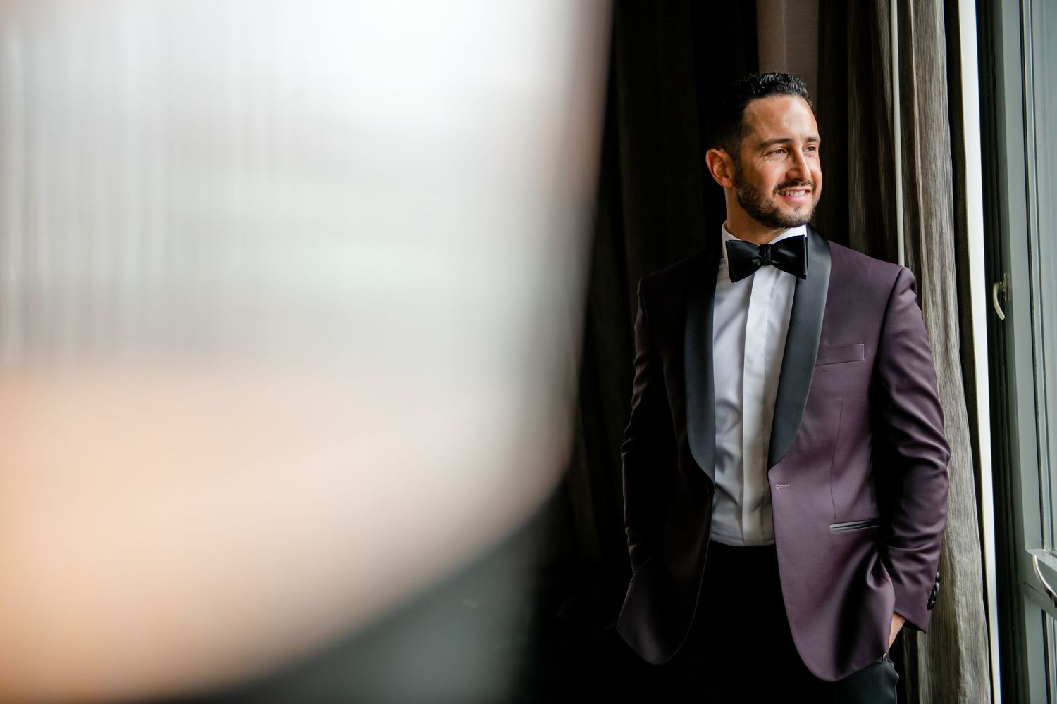Elegant formal attire against window with soft natural light creating dramatic atmosphere.
