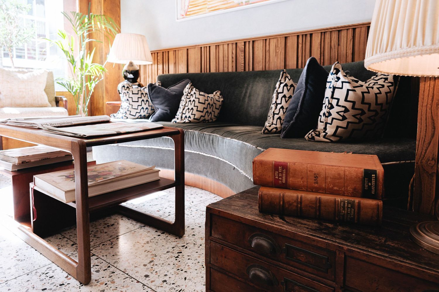 Contemporary living room with wooden furniture and leopard print accent pillows in warm lighting.