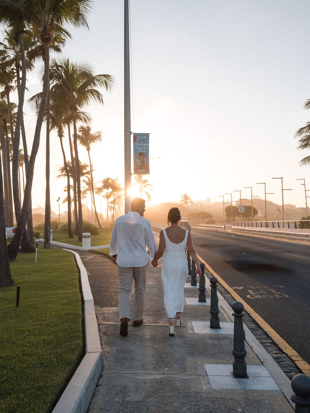 Couple walking along waterfront promenade during engagement session in San Juan Puerto Rico