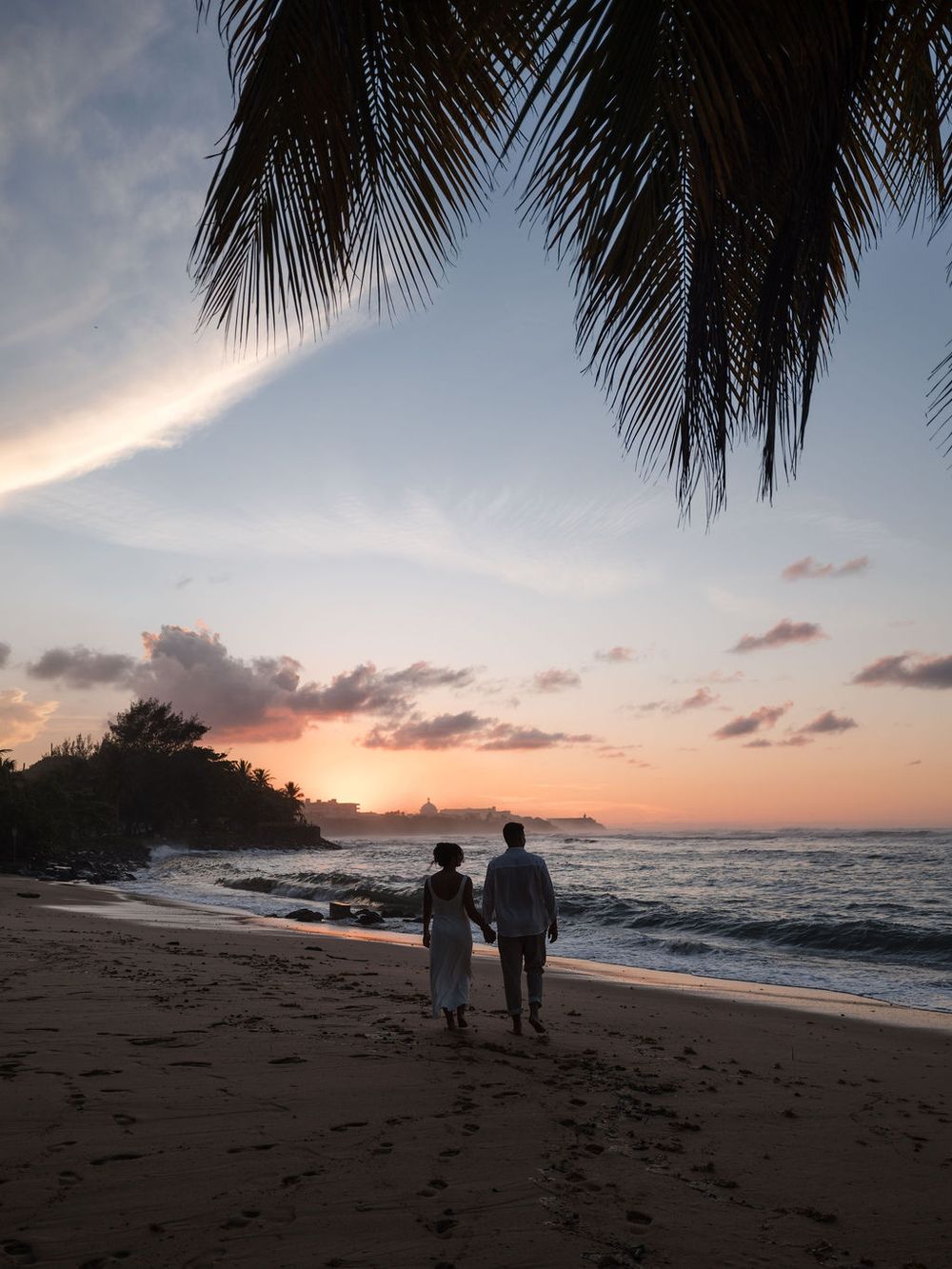 Silhouette of couple at sunset during engagement session at El Escambrón San Juan