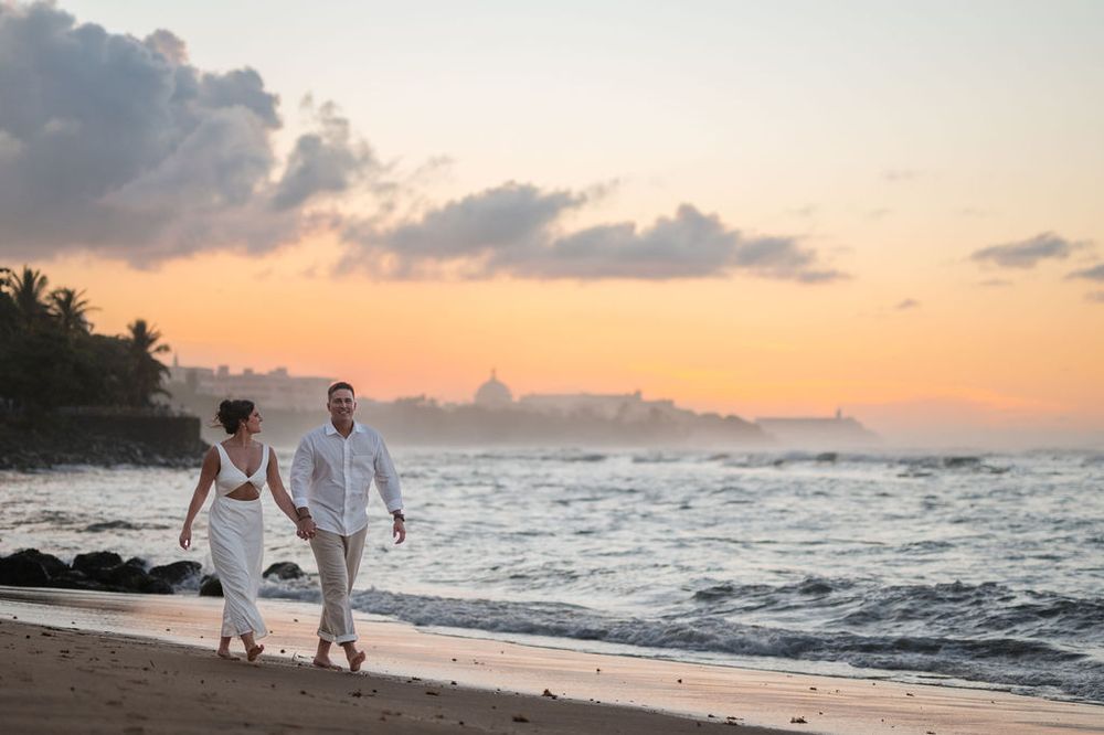 Couple walking together during sunset engagement session at El Escambrón beach