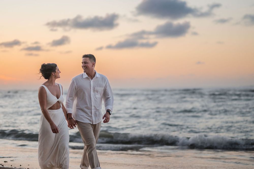 Couple embracing with ocean view during sunset engagement session at El Escambrón