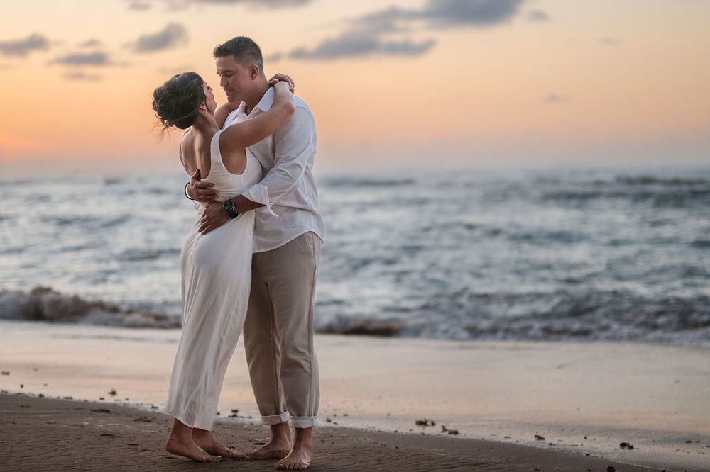 Couple walking along shoreline during golden hour engagement session in San Juan Puerto Rico