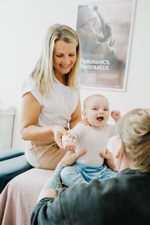 A heartwarming medical consultation with a happy baby in a bright clinical setting.