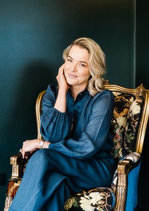 Elegant studio portraits in navy blue attire against dark background with gold accents.