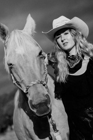 Black and white portrait series featuring a white horse and western style accessories.