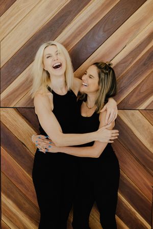 Candid friendship photoshoot on wooden chevron floor showing joyful moments.