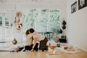 Peaceful indoor meditation scene with spiritual objects arranged on light wooden floor.