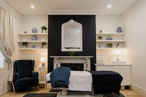 Modern white room interior with black accent wall and built-in shelving.
