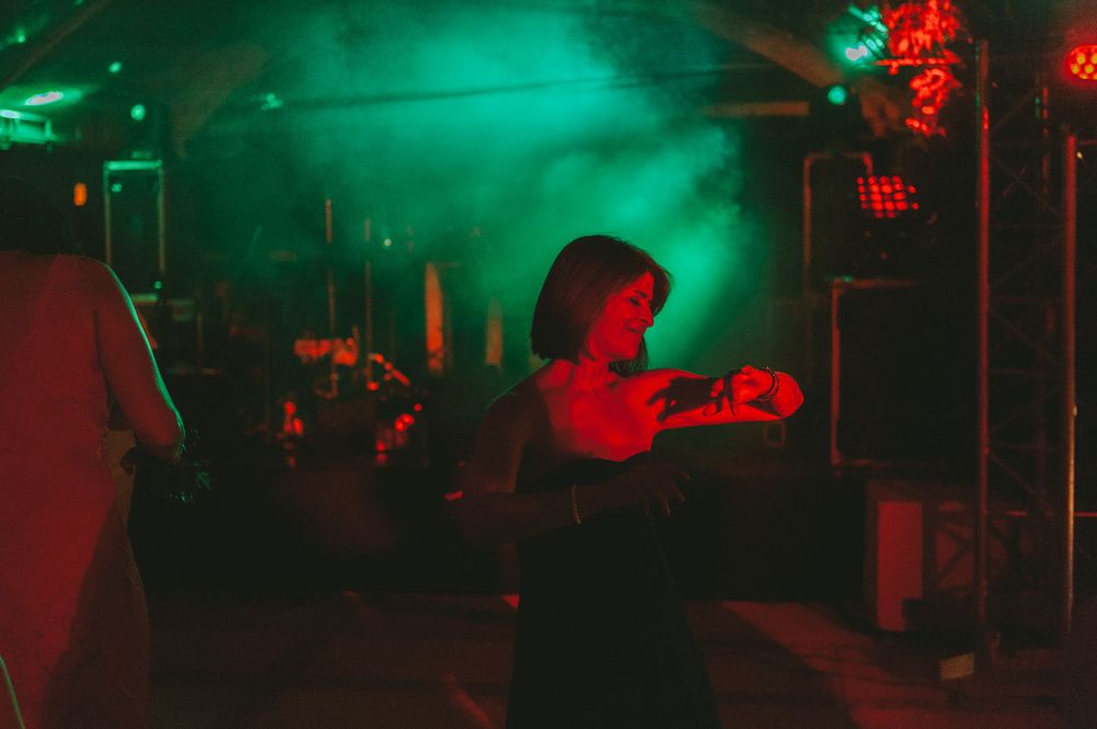 Wedding guests dancing bathed in green light.