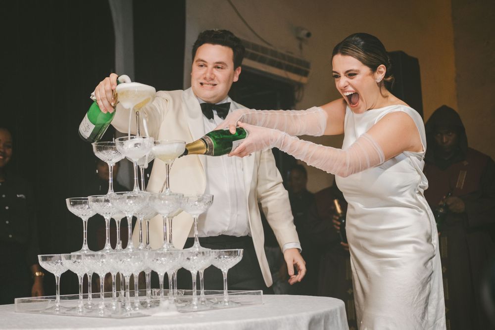 Newlyweds pouring champagne on a pyramid of glasses in Cartagena.