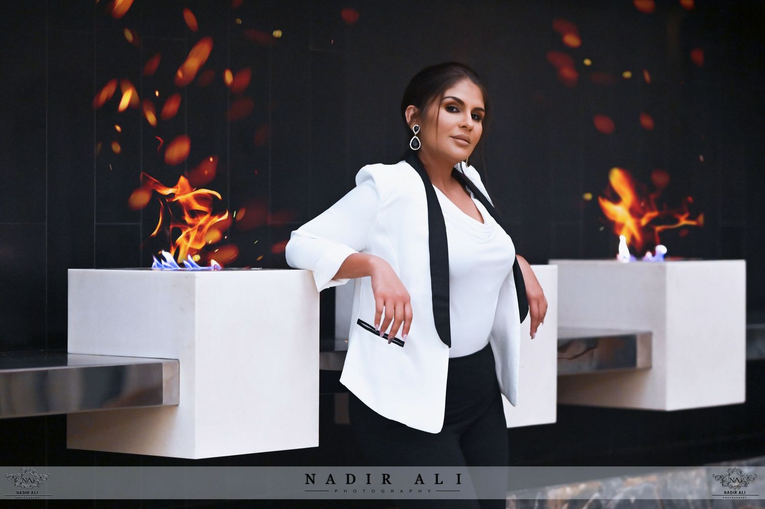Professional portrait with dramatic fire effects and white modern furniture.