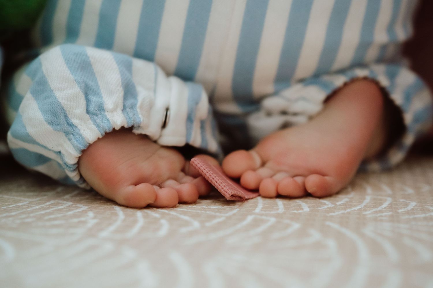 A collection of close-up photos showing bare baby feet against white and blue striped fabric backgrounds.