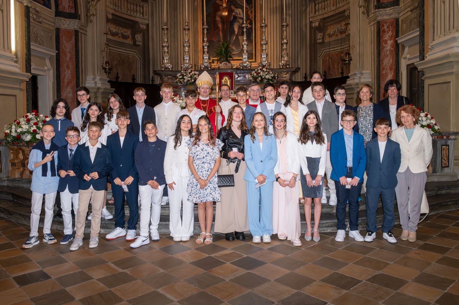 Large group photo of confirmation class and clergy gathered in an ornate church sanctuary.