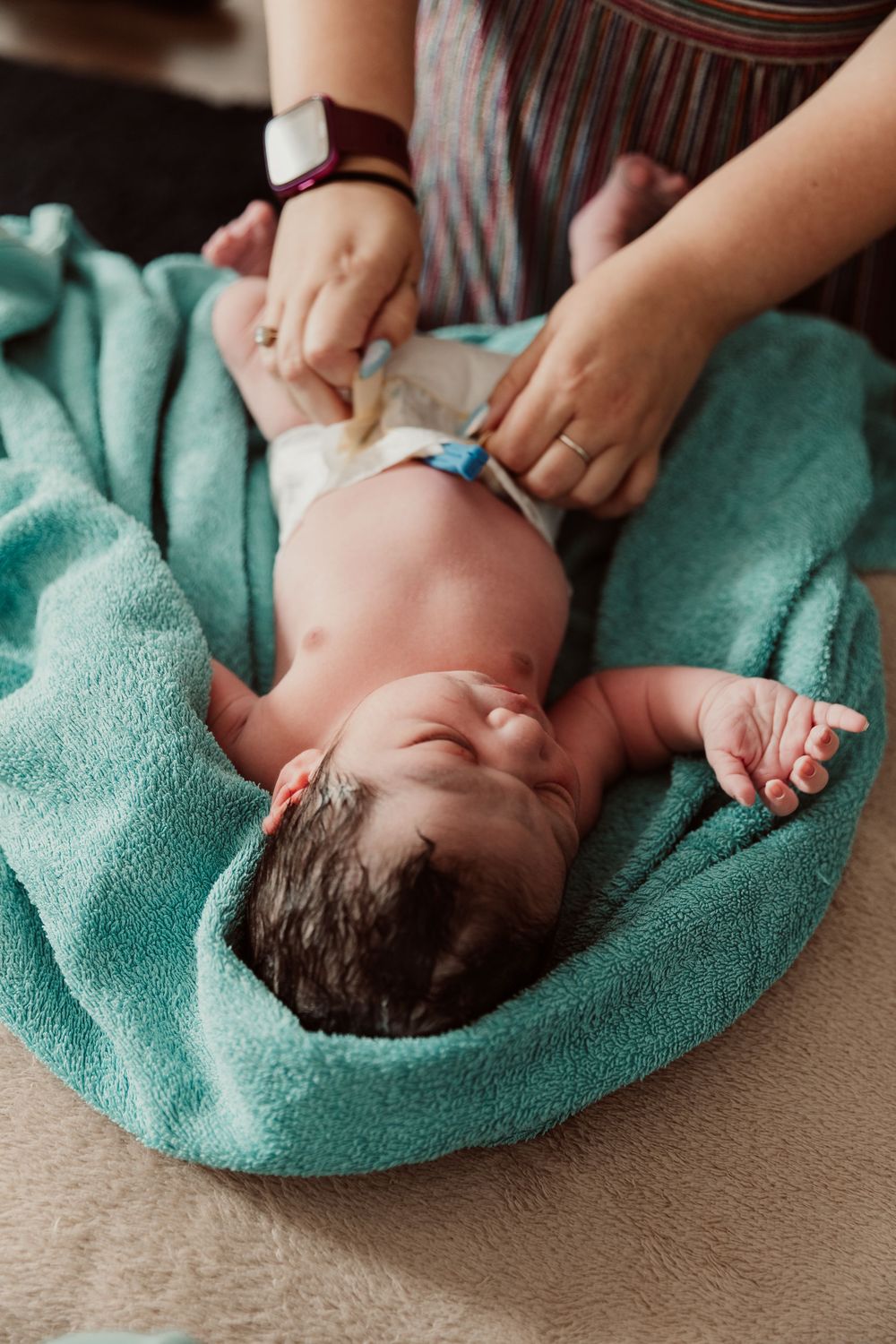 A baby lies on a turquoise towel while being gently dried after bath time in a series of connected photos.