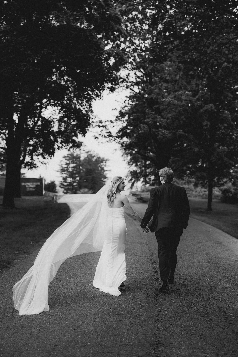 A black and white photo sequence shows a bride's veil flowing in the wind as the couple walks through a park setting.