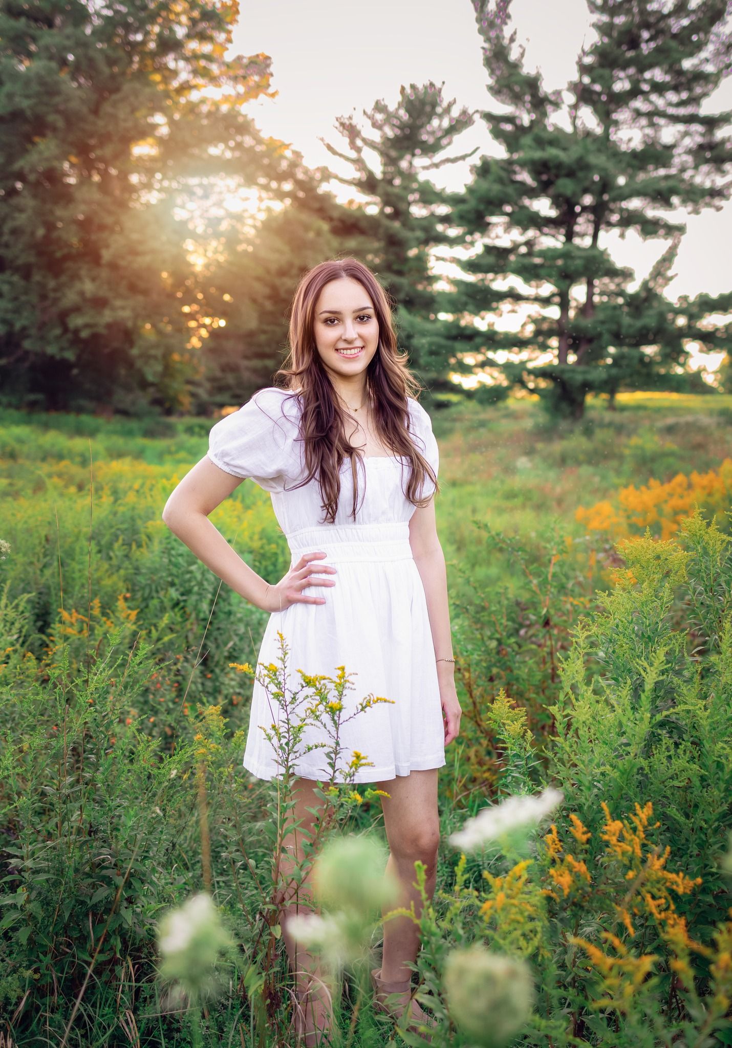 Summer portrait in a wildflower meadow wearing a white sundress.