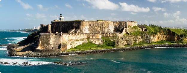Historic El Morro fortress stands majestically on rocky cliffs overlooking the blue Caribbean Sea in San Juan, Puerto Rico.