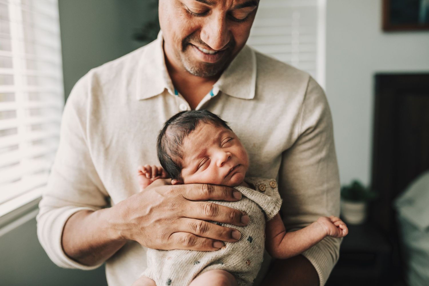A parent lovingly holds and bonds with their newborn baby in a series of tender moments at home.