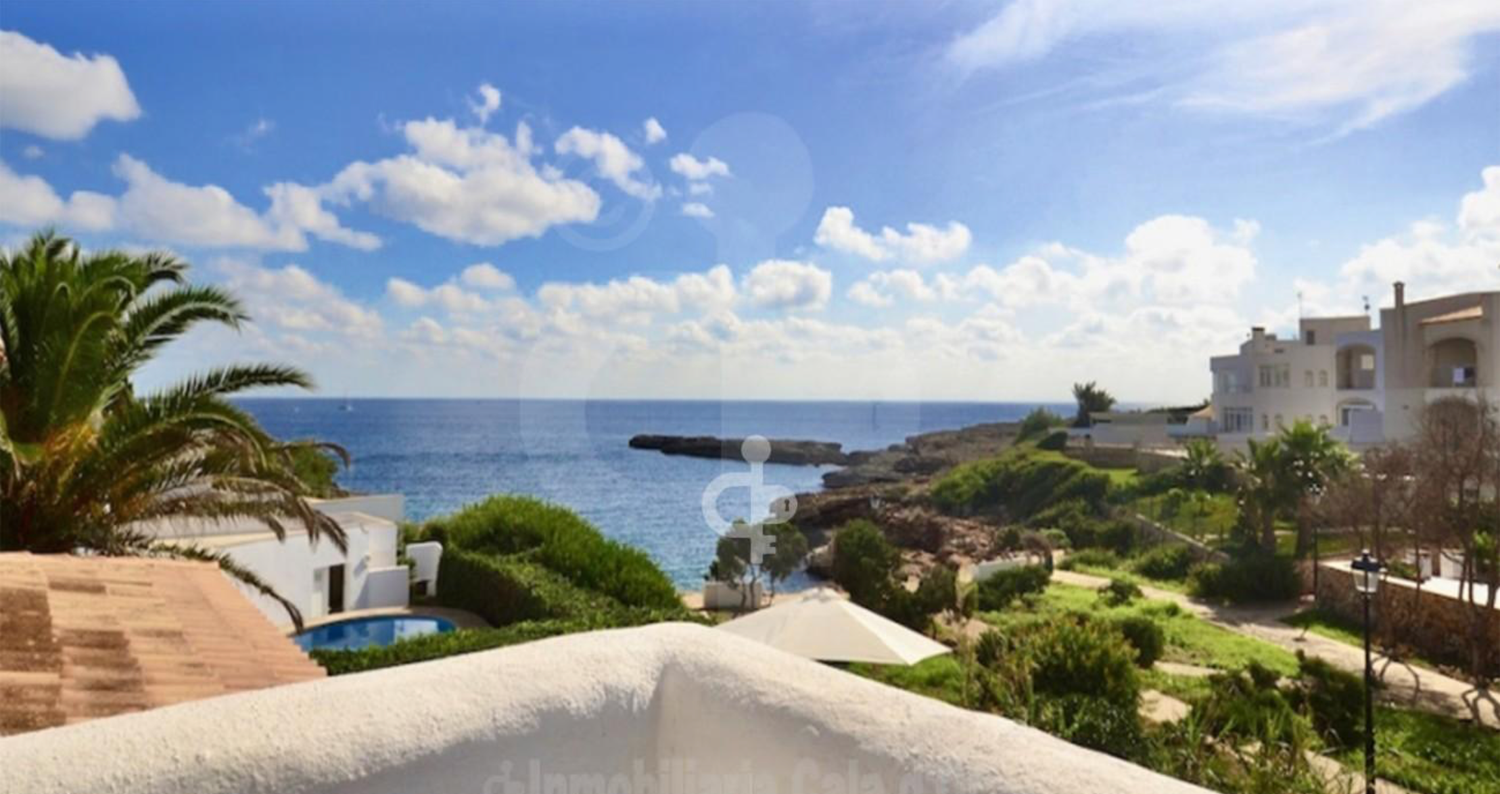 A panoramic coastal view shows Mediterranean beachfront villas and palm trees under bright blue skies.