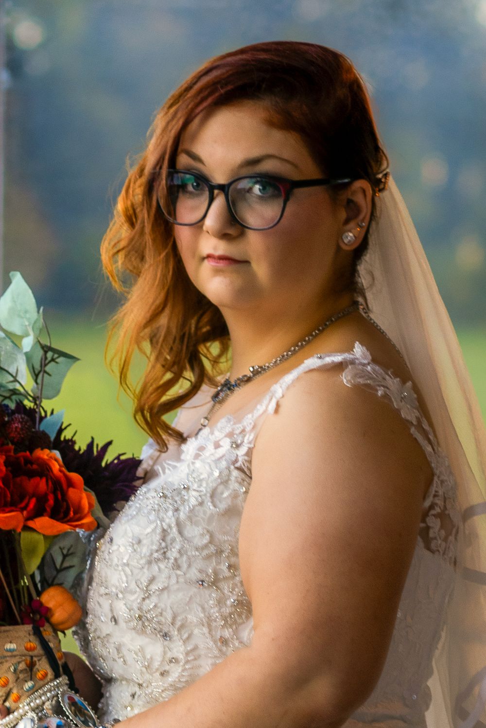Close-up bridal portraits showing intricate lace details and vibrant orange bouquet.