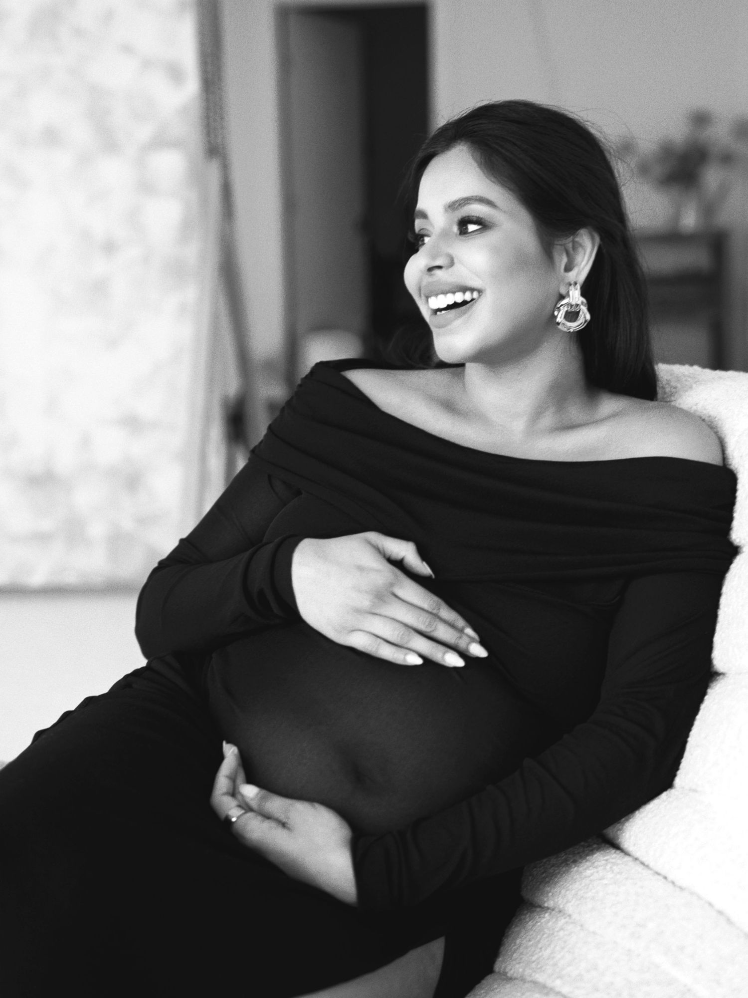 Black and white portrait series showing elegant woman in off-shoulder dress posing gracefully on sofa.