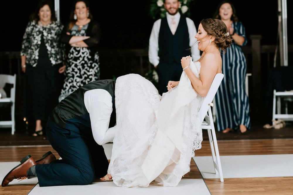 Wedding reception scene with guests dancing and celebrating on a wooden dance floor.