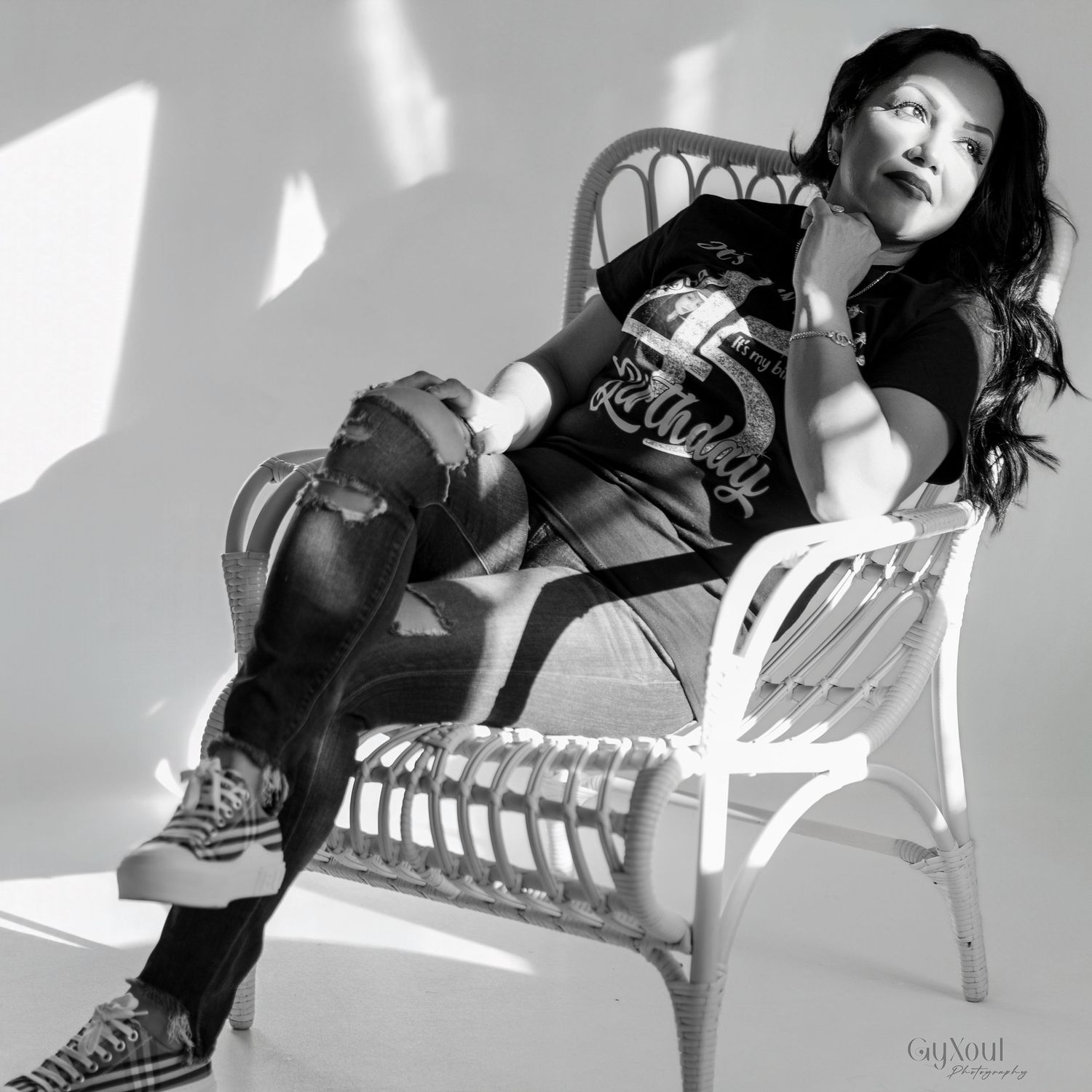 Black and white artistic photo series showing person in casual wear and sneakers posing on chairs in various positions.