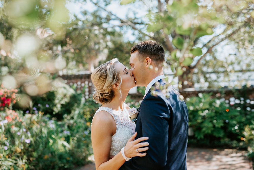Romantic garden wedding ceremony scene with blooming white flowers and greenery.