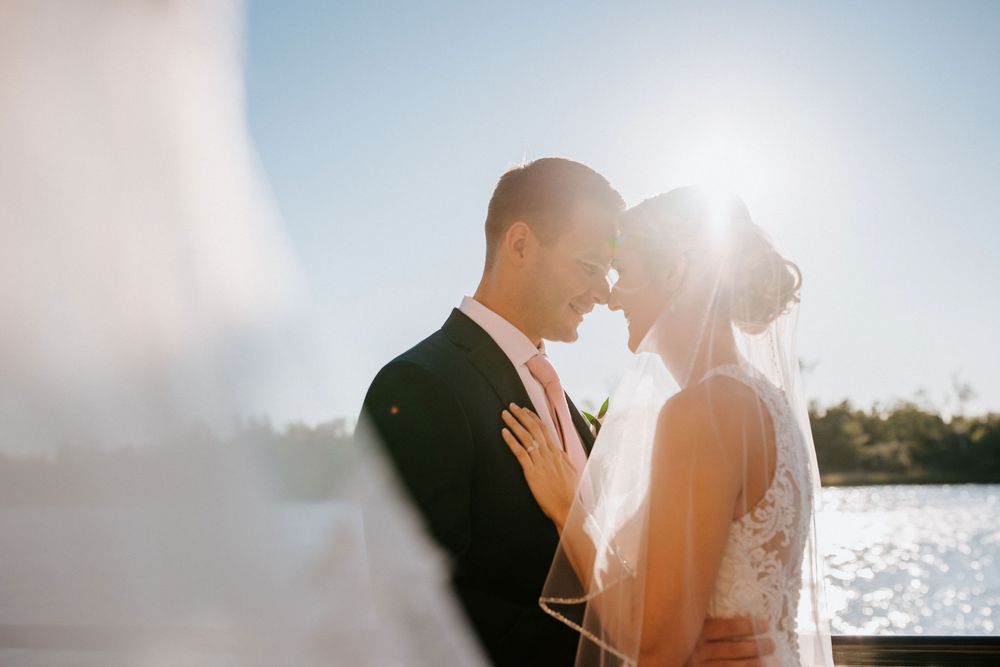 Silhouetted couple embracing during golden hour with sunlight creating a dreamy backlit effect.