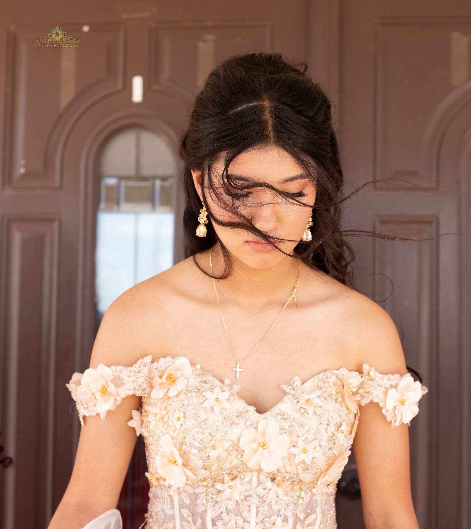Four bridesmaids in matching blush pink off-shoulder lace dresses pose together at an elegant indoor venue.