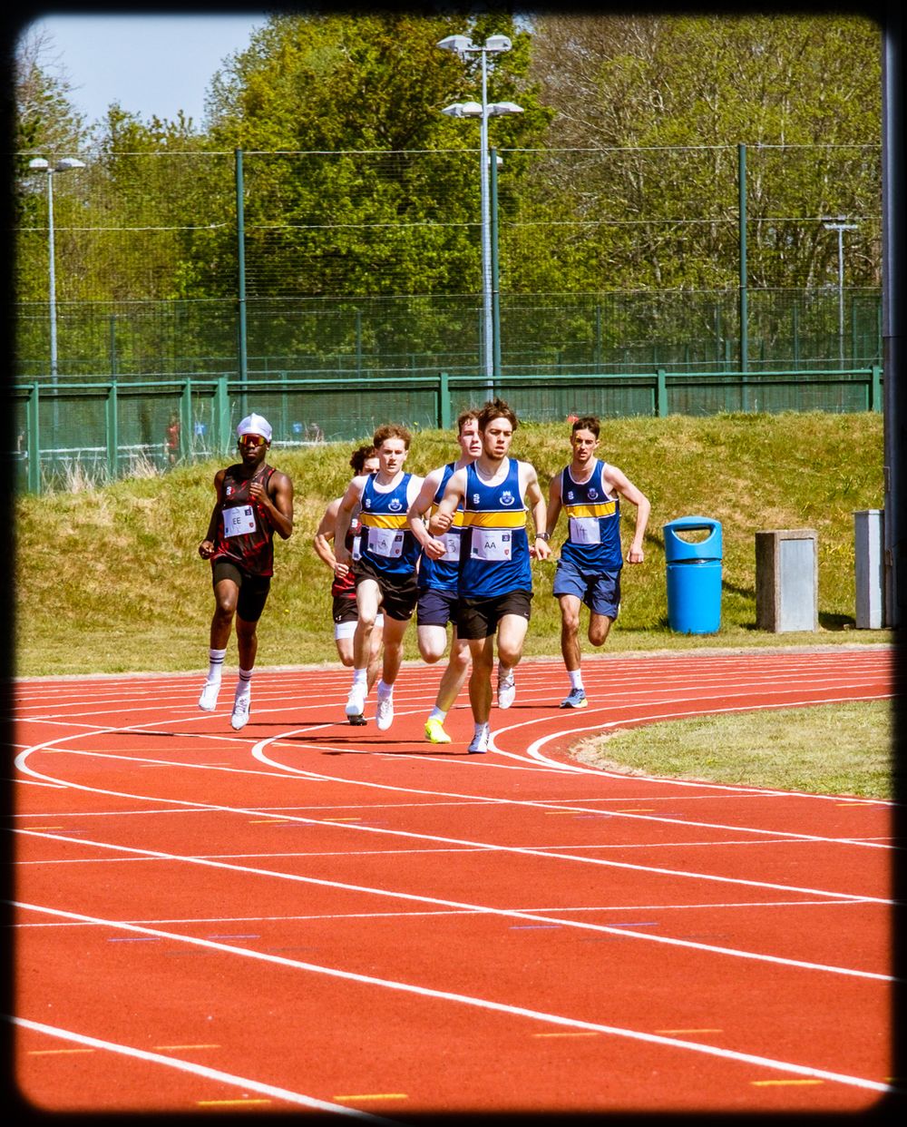 Athletes sprint on red running track lanes during competitive race sequence shown in progressive motion frames.
