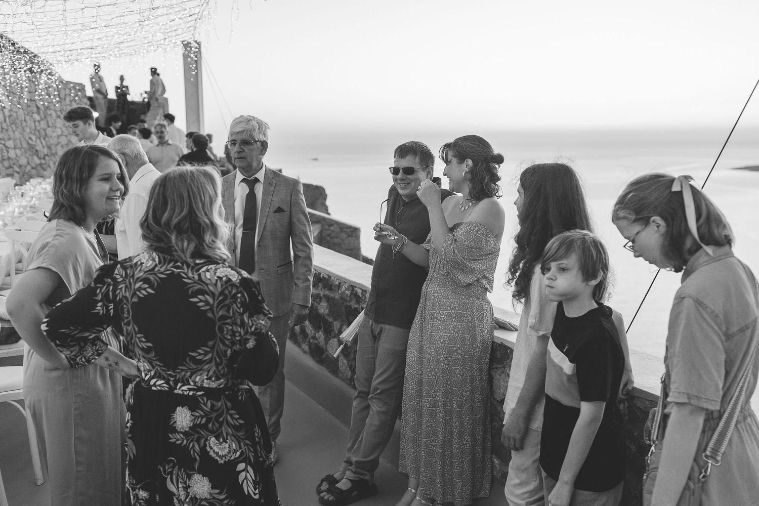 Guests gather at an elegant Santorini destination wedding overlooking megalachori caldera at El Viento.
