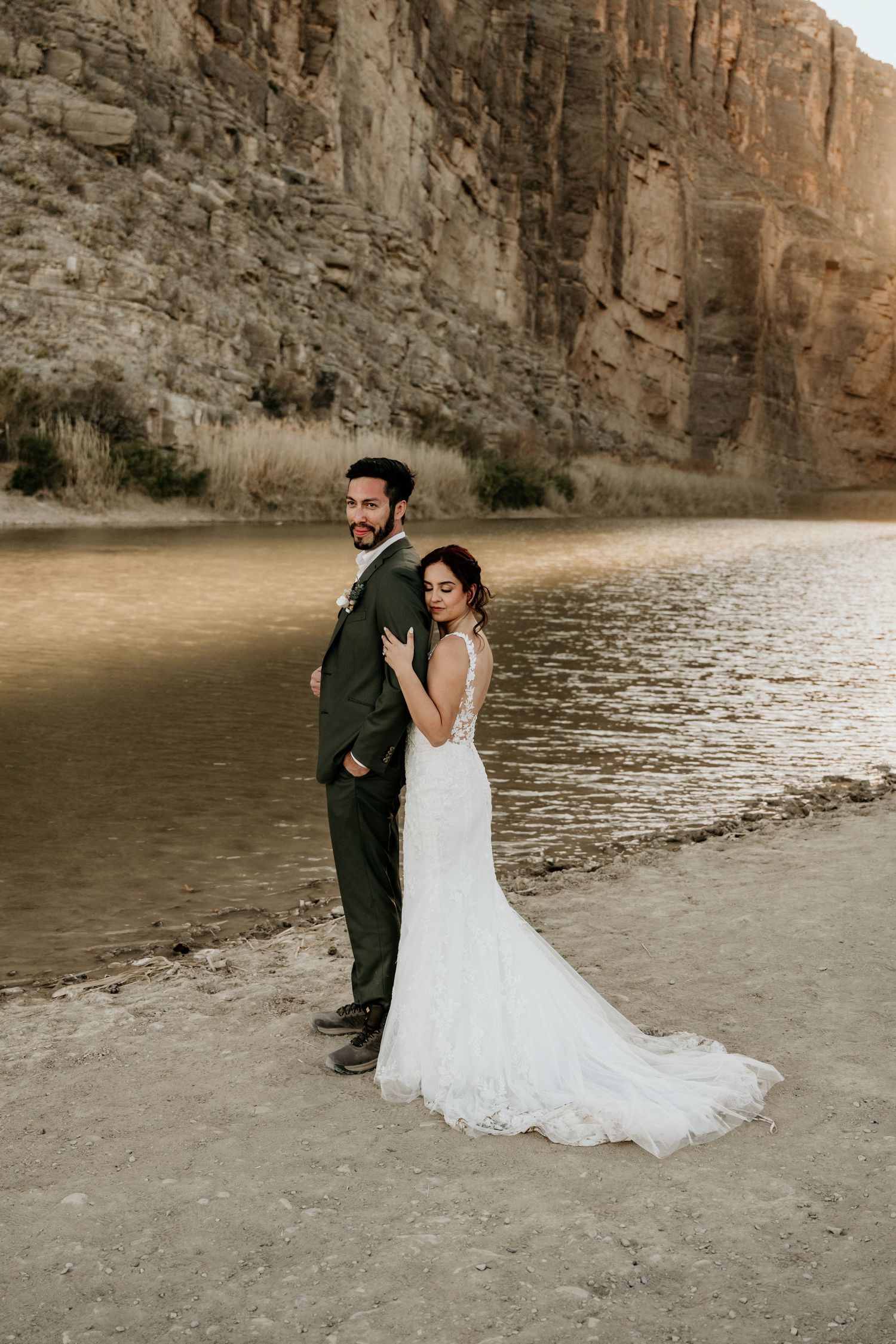 Romantic wedding portraits captured along a canyon shoreline during golden hour.