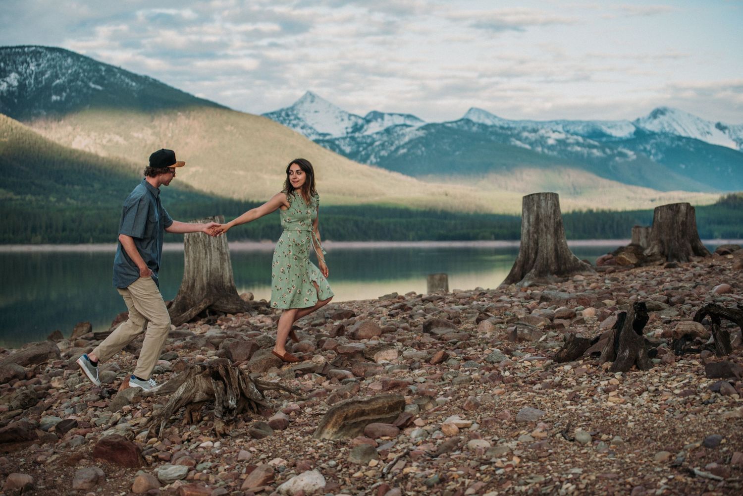 Couple enjoying scenic mountain views at Lake Minnewanka in Banff National Park during golden hour.