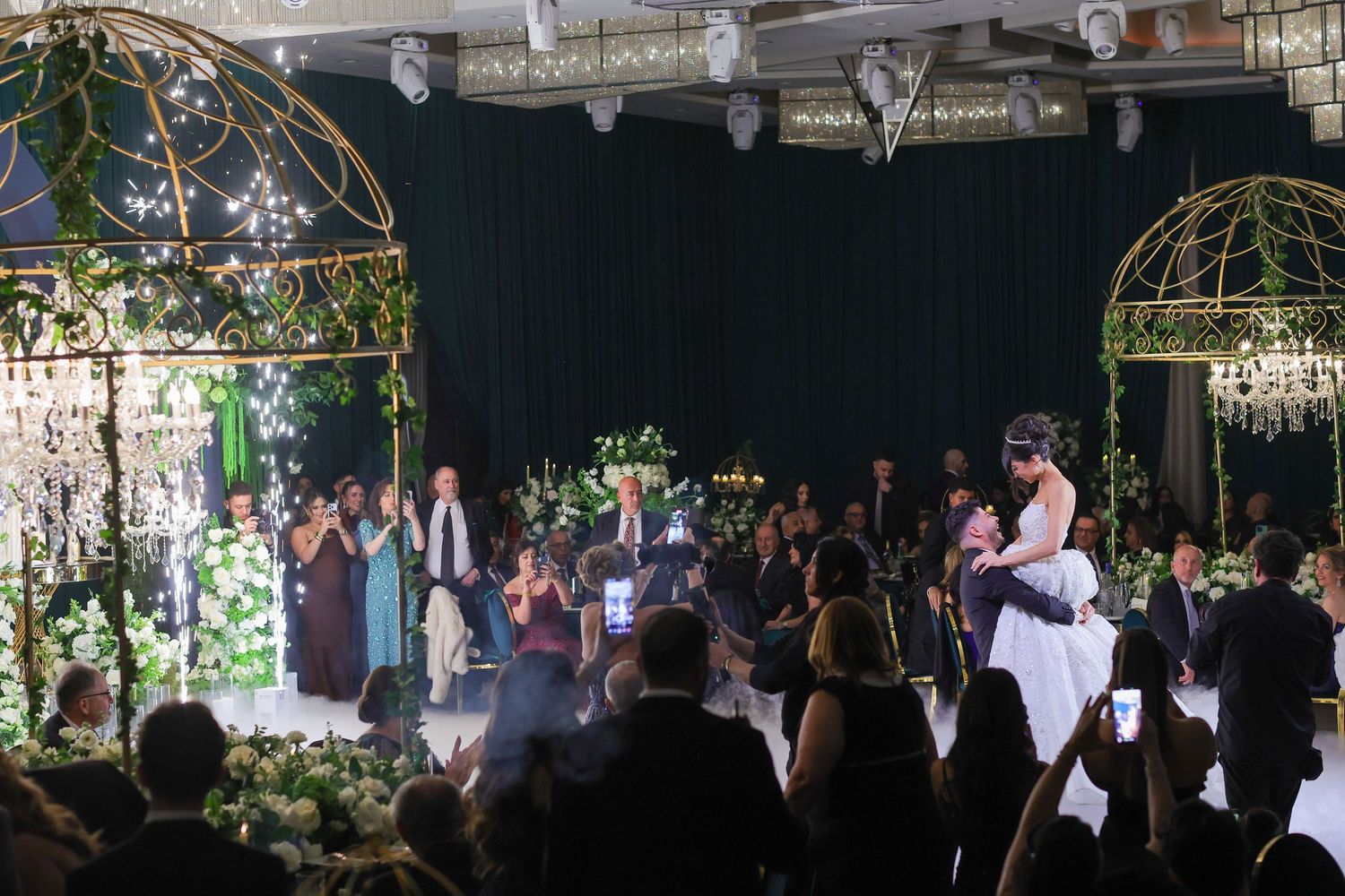A romantic wedding reception setup with glowing candles and string lights, creating a warm ambiance under a glass dome.